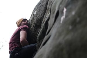 A man climbing a rock outside