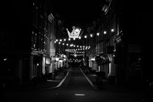 Looking down a street at night in Amsterdam, lights zig-zagging the whole way down.