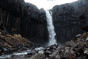 A very tall waterfall, water rushing down the rocks