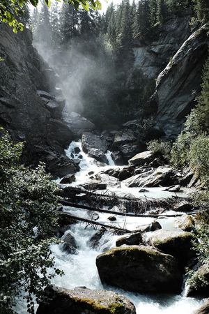 Spray comes off a waterfall with a river running towards the camera